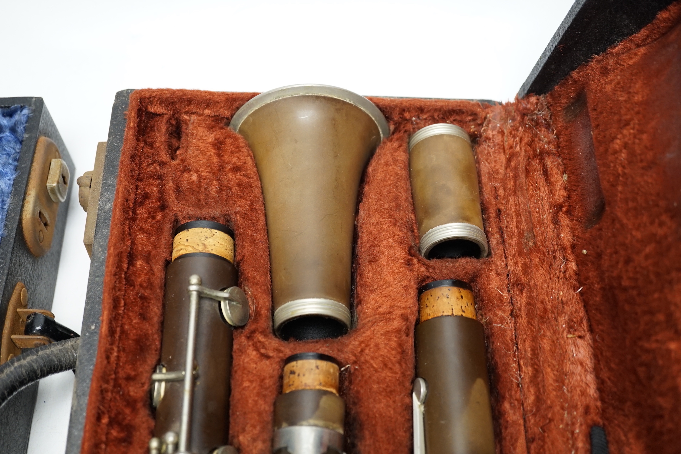 Two cased unmarked clarinets with early key systems, one mid 19th century in rosewood, one with light brown Bakelite body